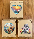 3 Qiuenisray 500 Piece Wooden Puzzles Rabbit, Sunflower Butterfly, Colored Stone. Fixed Price $98.00.
