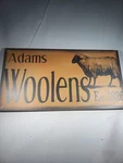 Western Wooden Mercantile Sign Says Adams Woolens. Fixed Price $24.99.